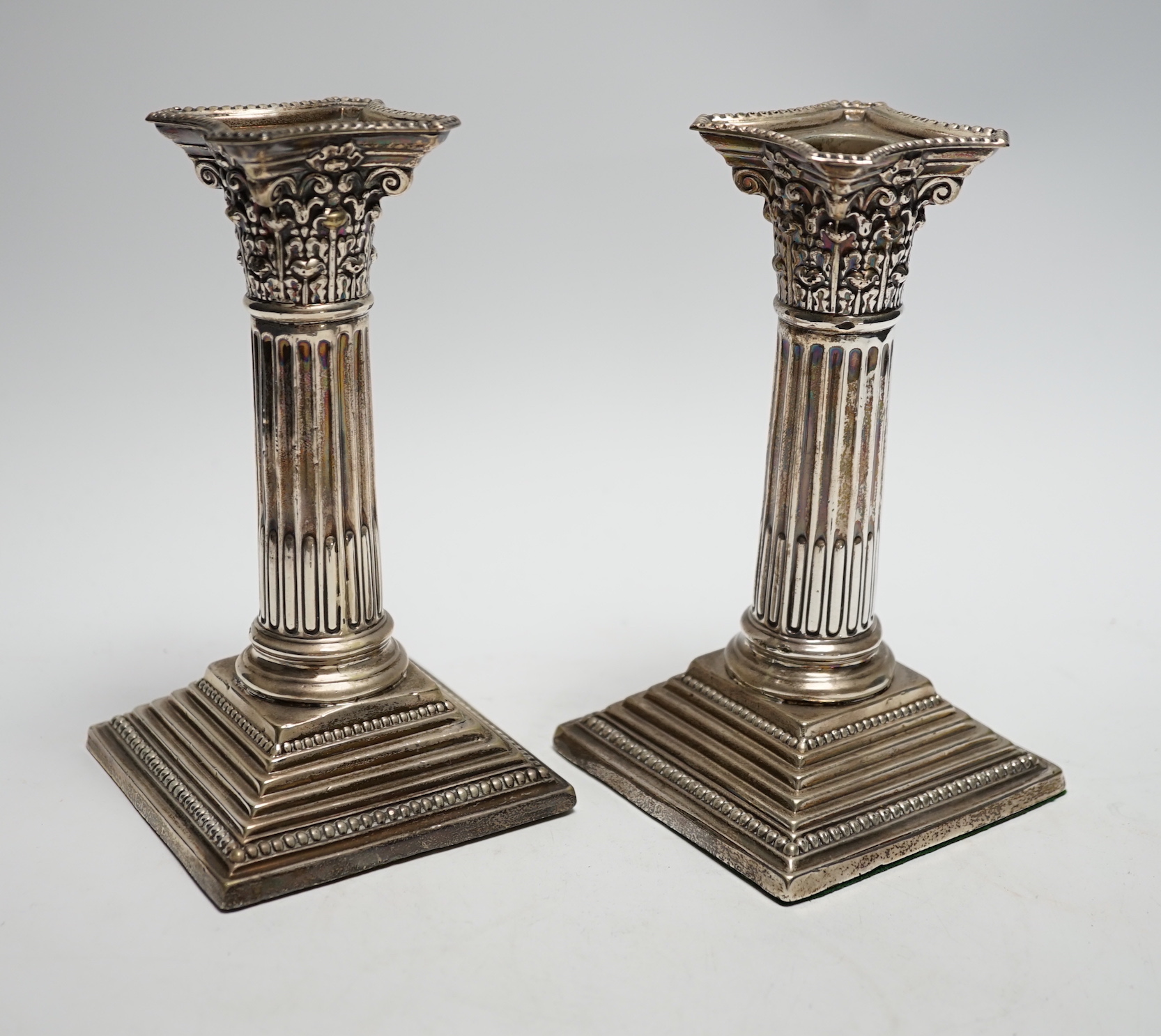 A pair of George V silver mounted Corinthian column dwarf candlesticks, London, 1911, 15.7cm, weighted.